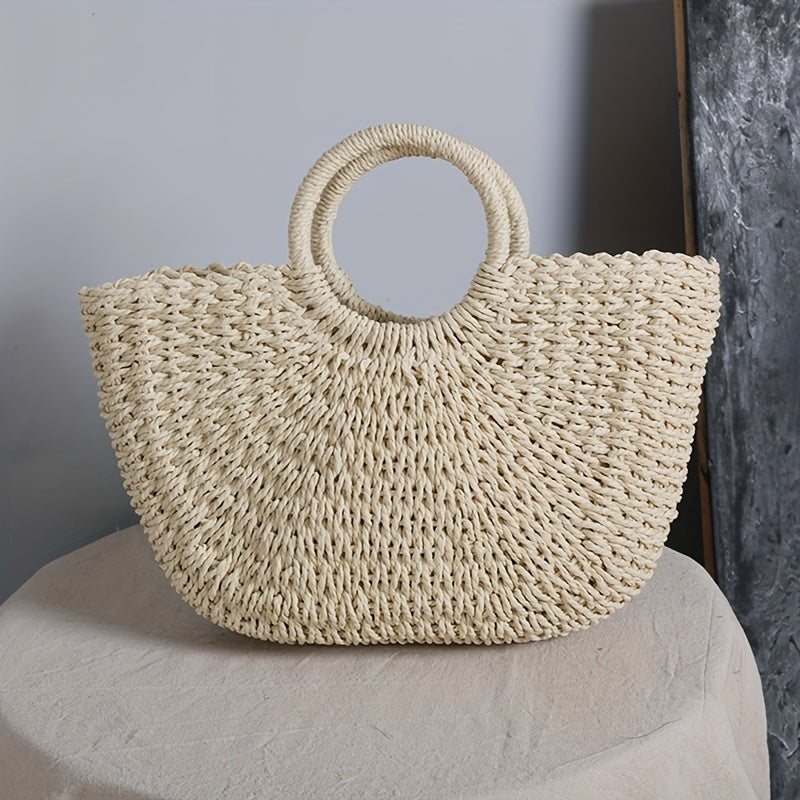 Bolso media luna beige con asas de aro sobre mesa vestida