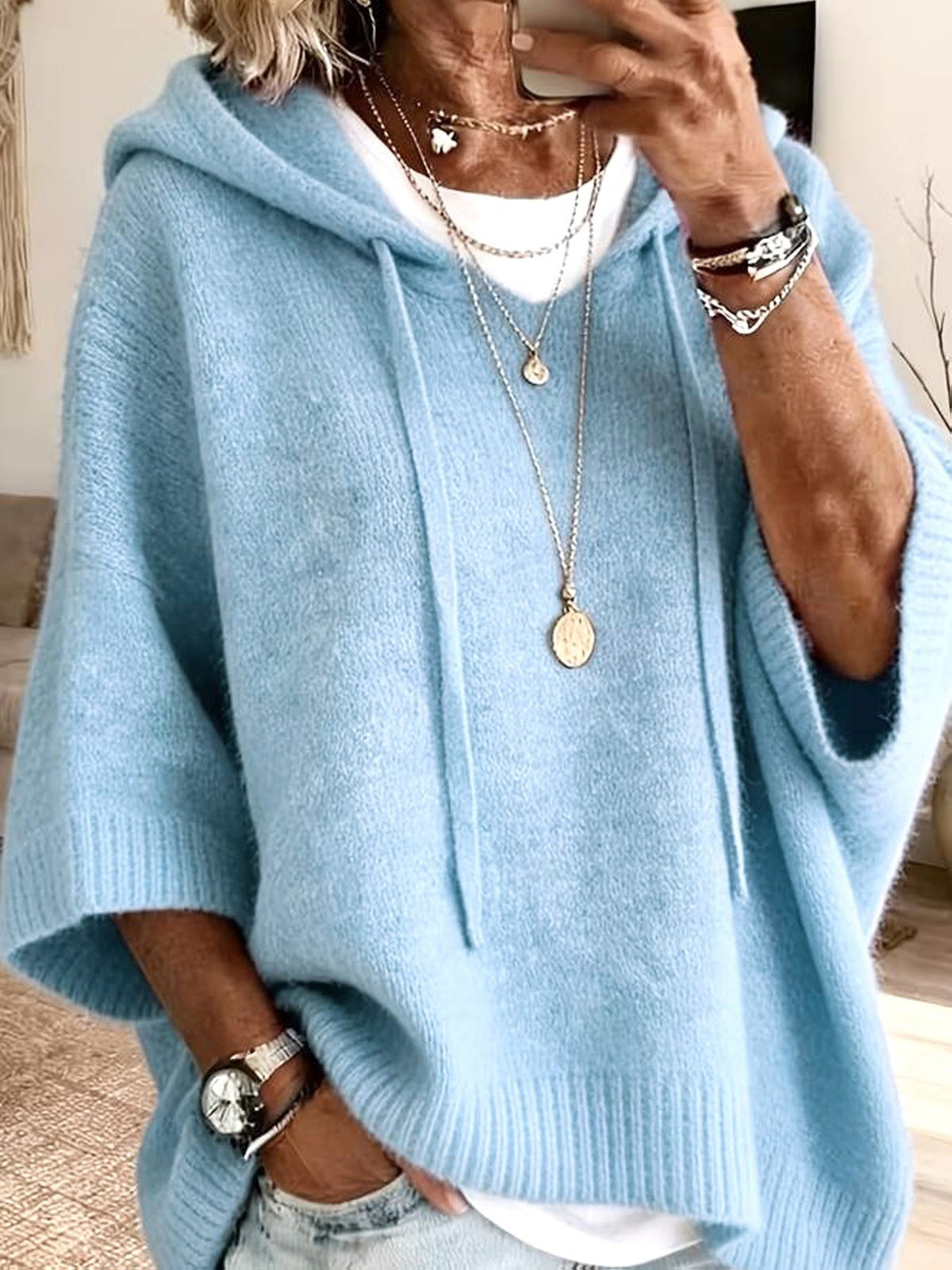 Poncho Micaela en azul claro visto de cerca, con la capucha levantada