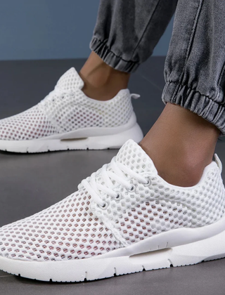 Zapatillas ortopédicas de malla en blanco llevadas puestas, vista en ángulo
