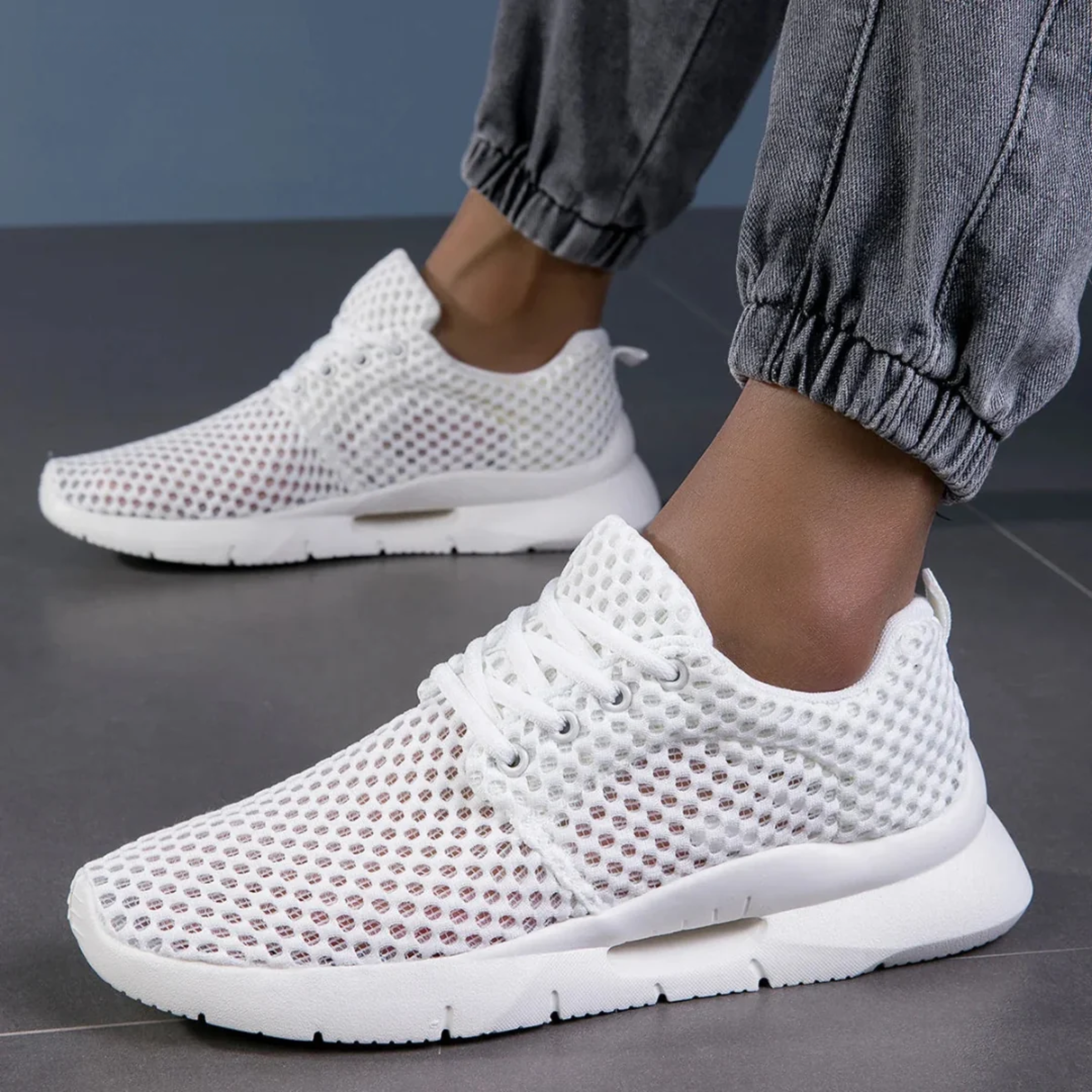 Zapatillas ortopédicas de malla en blanco llevadas puestas, vista en ángulo