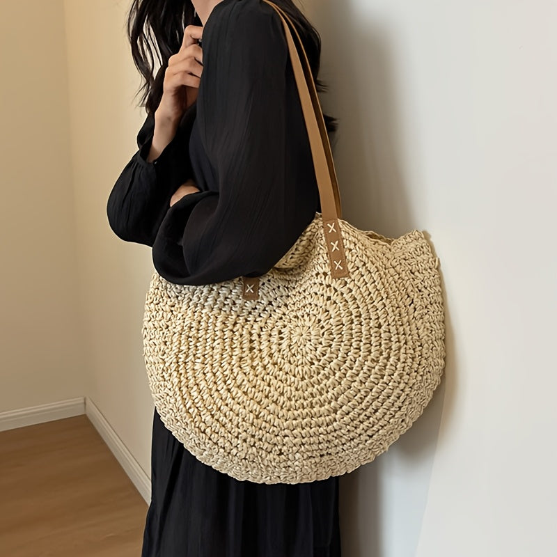 Modelo con vestido negro llevando el bolso redondo crema al hombro