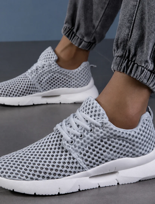 Zapatillas ortopédicas de malla en gris llevadas puestas, vista en ángulo