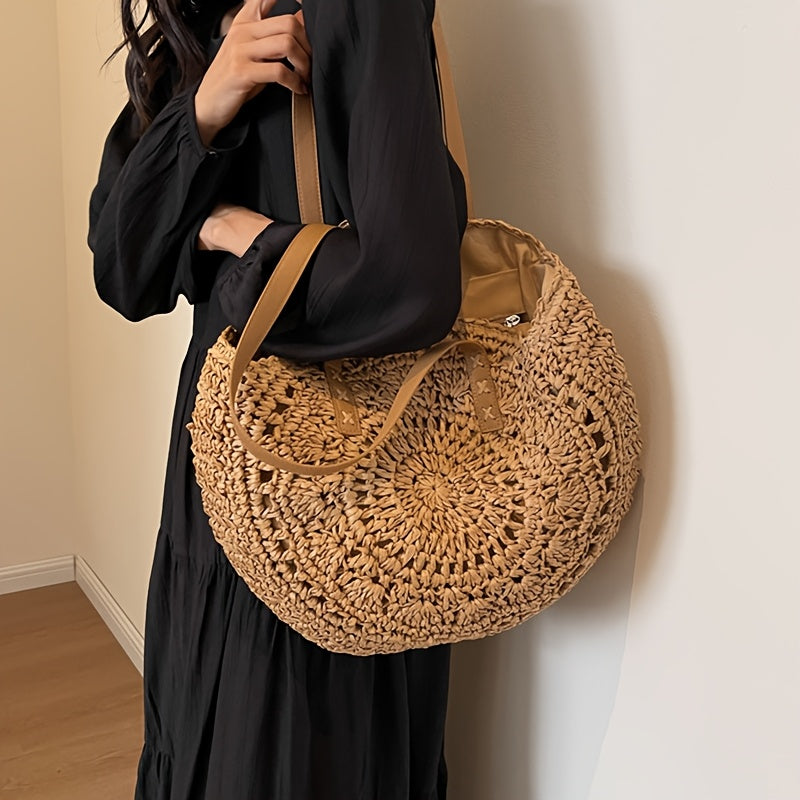 Modelo con vestido negro llevando el bolso redondo calado al hombro