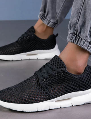 Zapatillas ortopédicas de malla en negro llevadas puestas, vista en ángulo