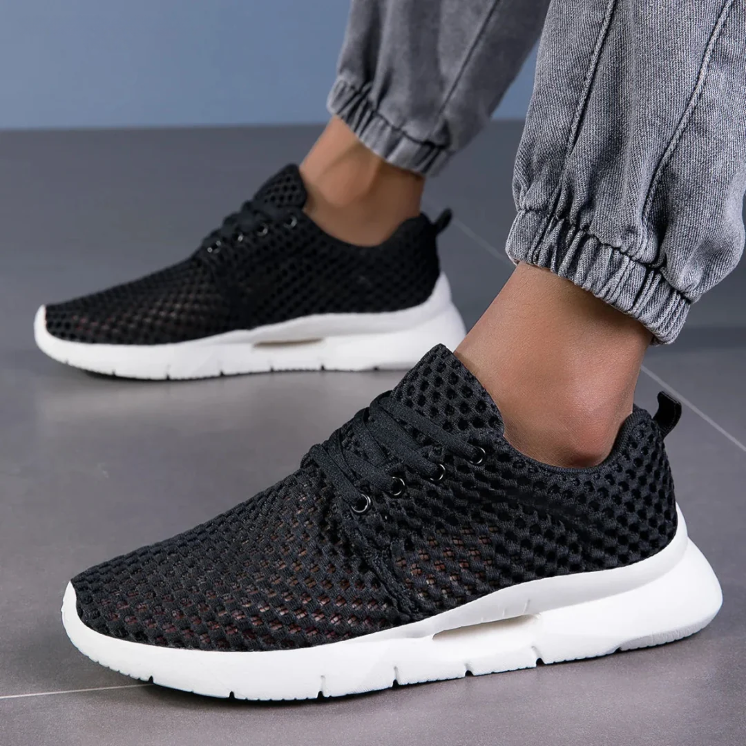 Zapatillas ortopédicas de malla en negro llevadas puestas, vista en ángulo