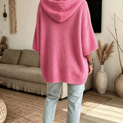 Espalda del poncho Micaela en rosa fucsia, con la capucha caída