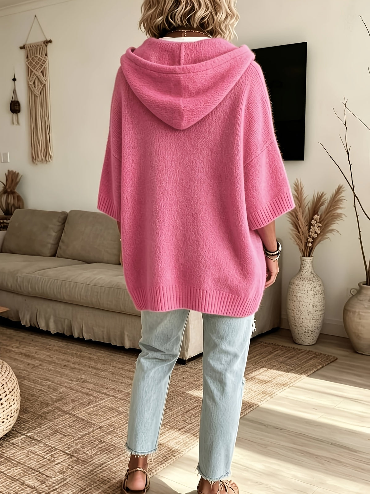 Espalda del poncho Micaela en rosa fucsia, con la capucha caída