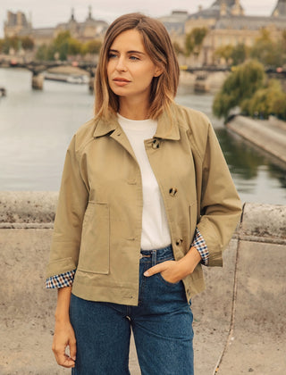 Mujer de frente con la chaqueta corta Olalla en caqui, abierta sobre camiseta blanca y vaqueros