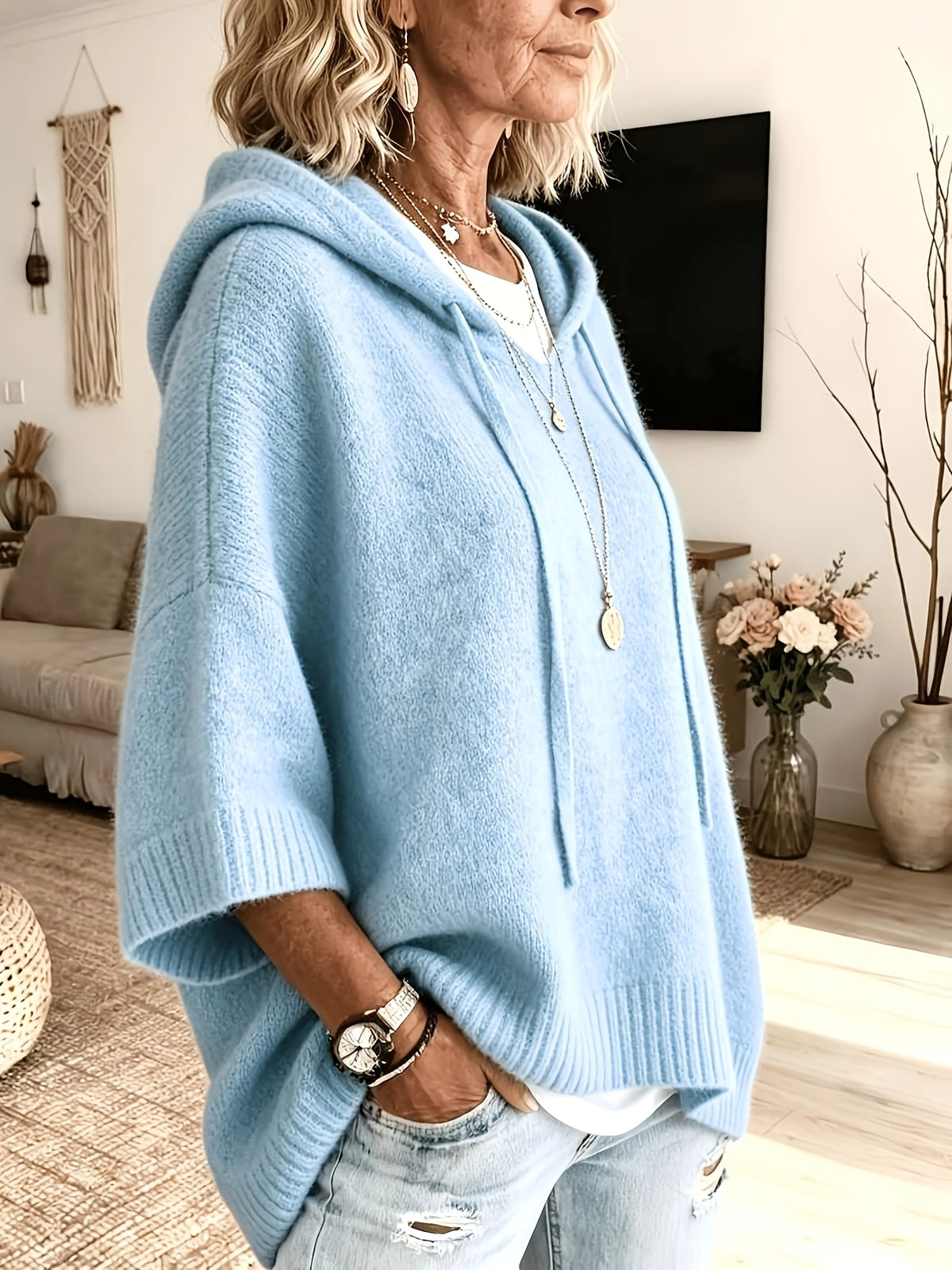 Poncho Micaela en azul claro de perfil, con el puño de canalé