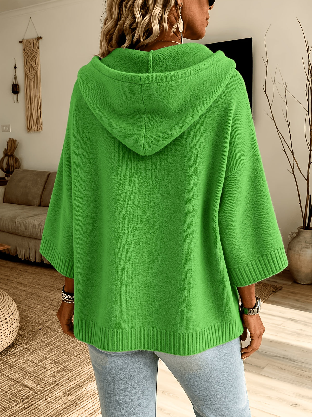 Espalda del poncho Micaela en verde hierba, con la capucha caída