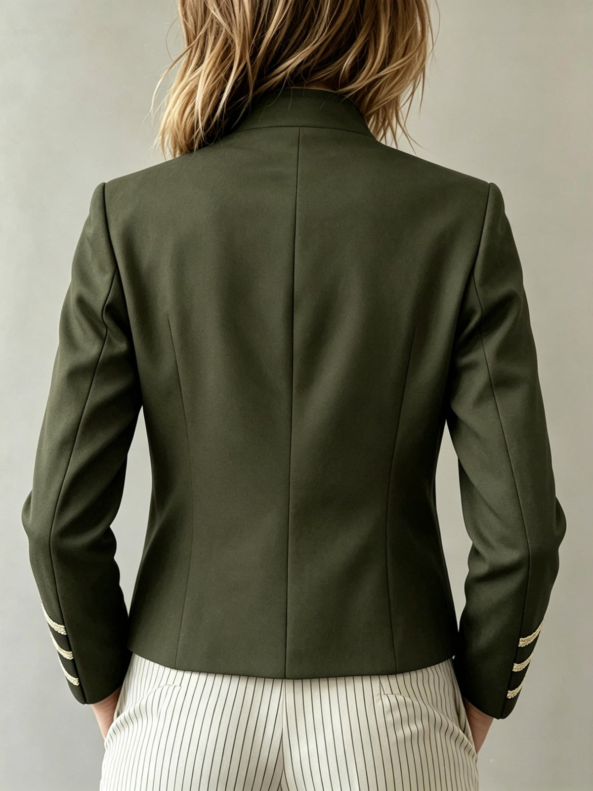 Espalda de la chaqueta Rosalía en verde militar, con el bajo a la cintura