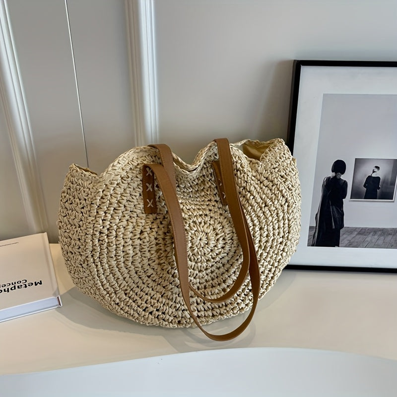Bolso redondo crema en ángulo sobre mesa blanca