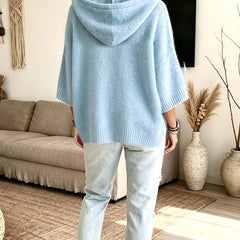 Espalda del poncho Micaela en azul claro, con el bajo más largo detrás