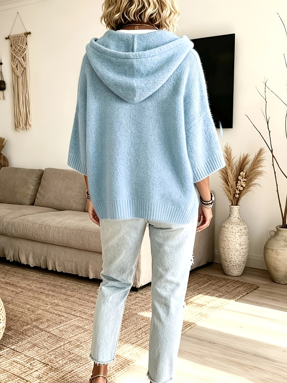 Espalda del poncho Micaela en azul claro, con el bajo más largo detrás