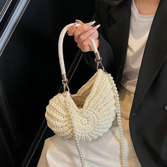 Modelo mostrando el bolso concha con la cadena de perlas